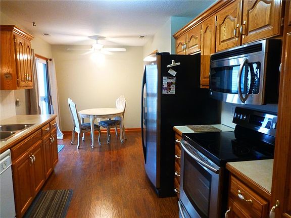 Kitchen and Dining area. Range , Microwave, and Refrigerator all stay with the home. Sliding glass door to the covered patio. Custom Oak cabinets.