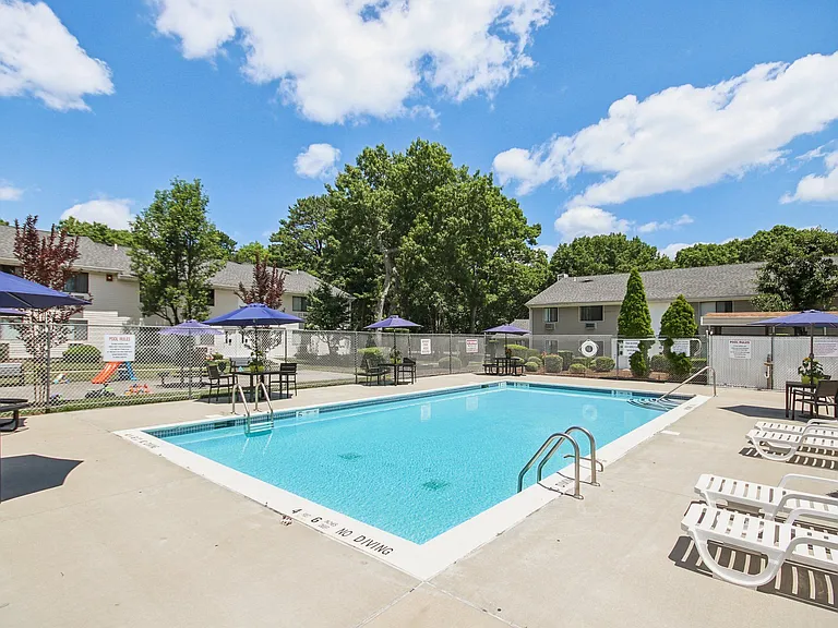 view of our sparkling swimming pool with chairs and umbrellas