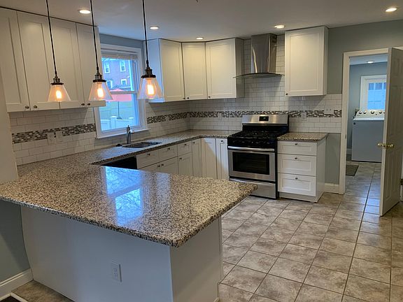 Open kitchen with peninsula, stainless steel appliance, white kitchen cabinet, pantry