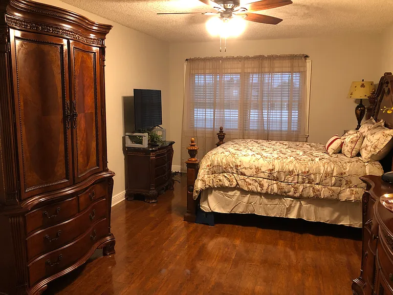 master bedroom with private bathroom and walk in closet. tv in hutch