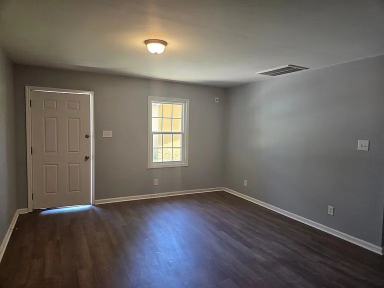Welcome into a bright and spacious living room designed for comfort and flexibility. Featuring durable wood-style flooring, modern neutral paint, and abundant natural light, this inviting space offers plenty of room for relaxing, entertaining, or creating