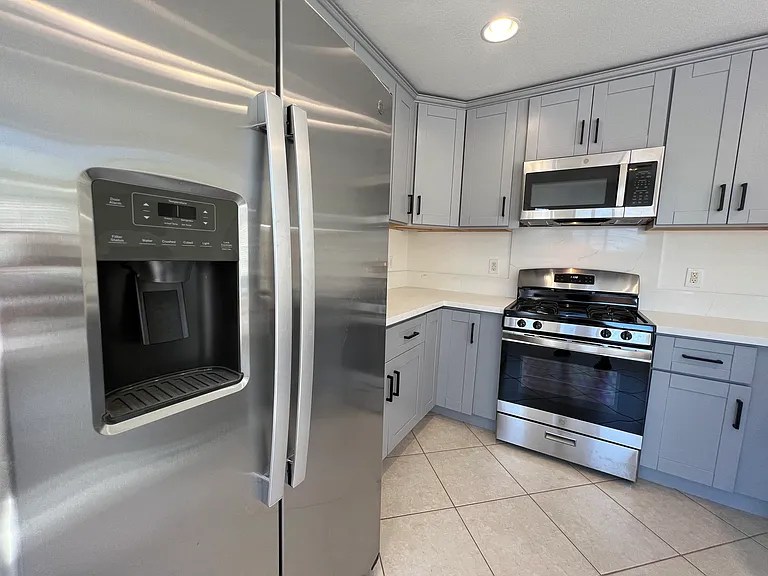 Stainless steel appliances, including French door refrigerator, range and microwave.
