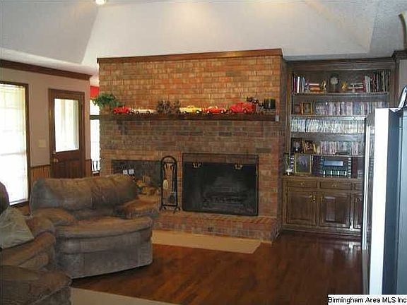 Den with hardwoods and large fireplace with built-ins. Vaulted ceiling, lots of windows, and recesse