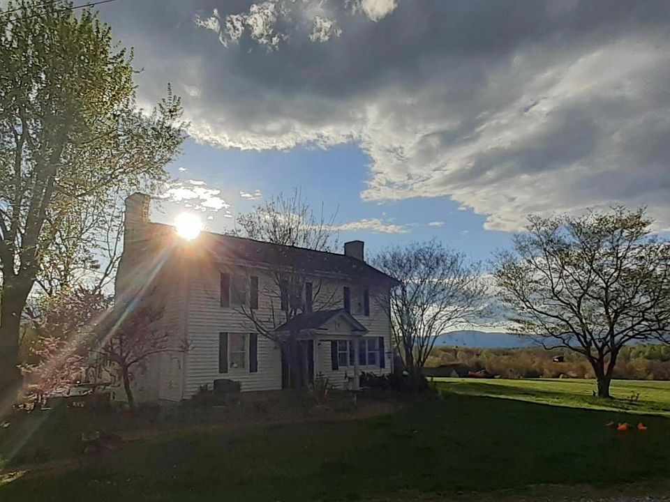 Farmhouse and garage. Blue Ridge Mountains in background.