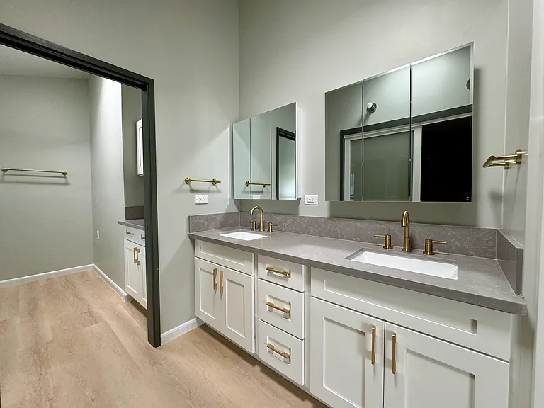 Primary bathroom with double vanity sinks, medicine cabinet mirrors and quartz countertops.