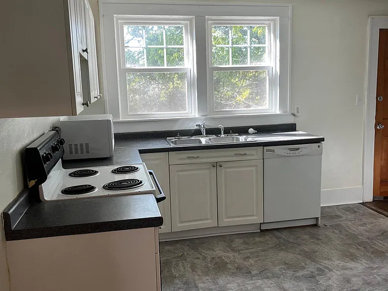 Kitchen with new flooring, windows looking out to back yard