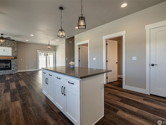 Kitchen island with seating and a pantry closet. Open concept great room with good flow into living and dining.
