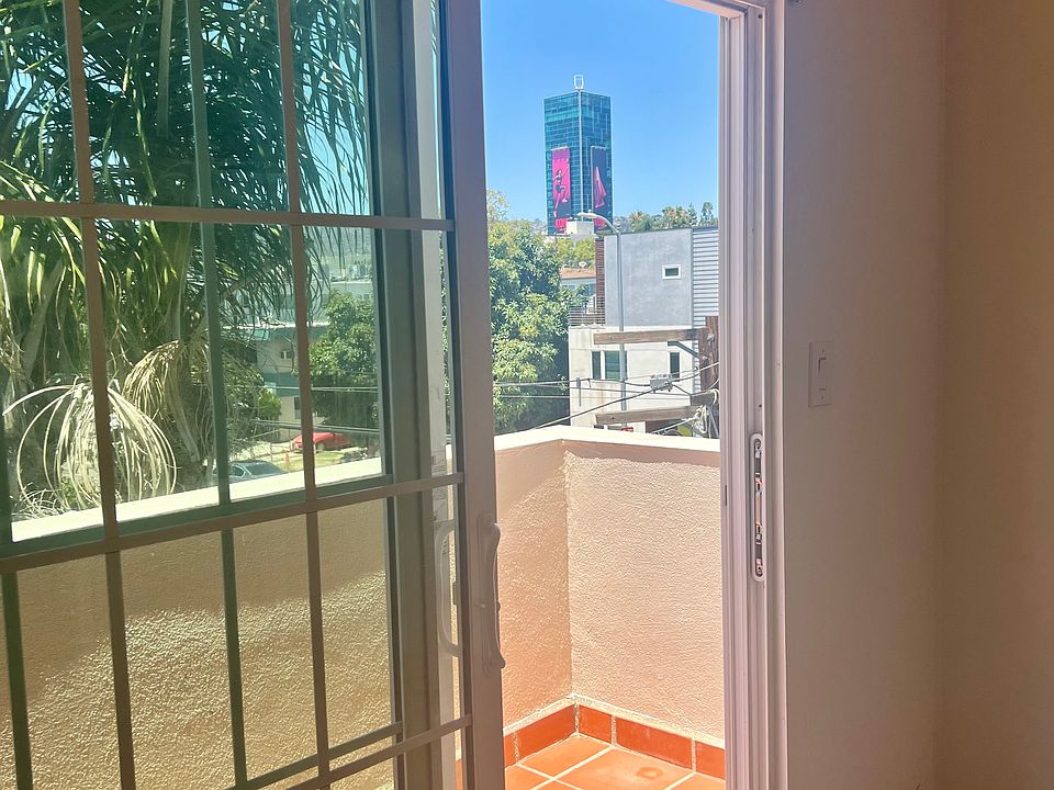 Balcony sliding door with window coverings, facing Gower St.