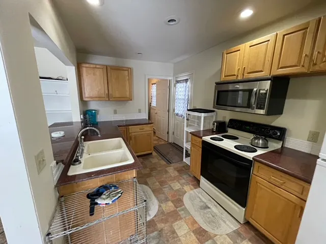 Fully stocked kitchen leading to the side door and laundry room.