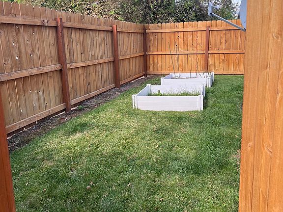 Fenced backyard with two raised flower beds