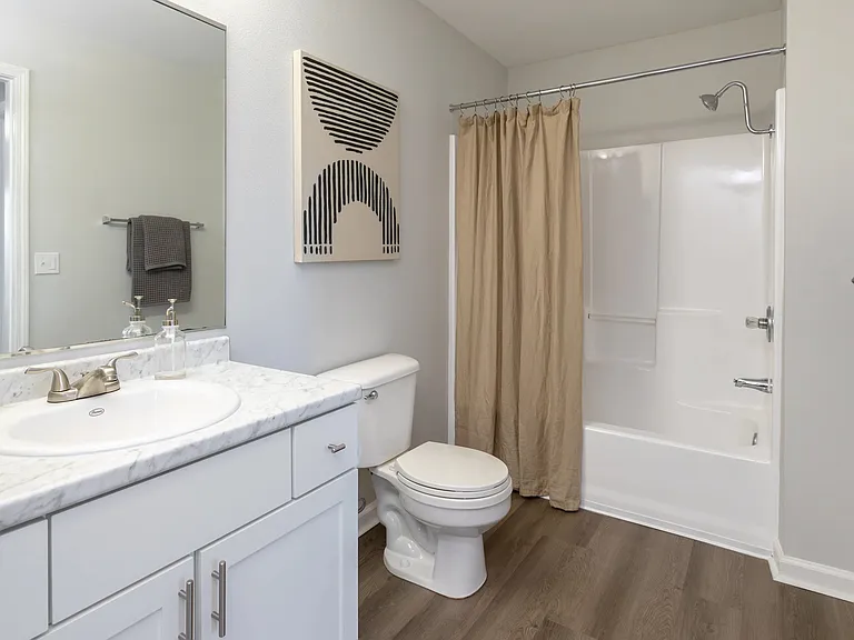 Pamper yourself with the expansive master bathroom's oversized vanity and mirror and enjoy elegant wood-style flooring.