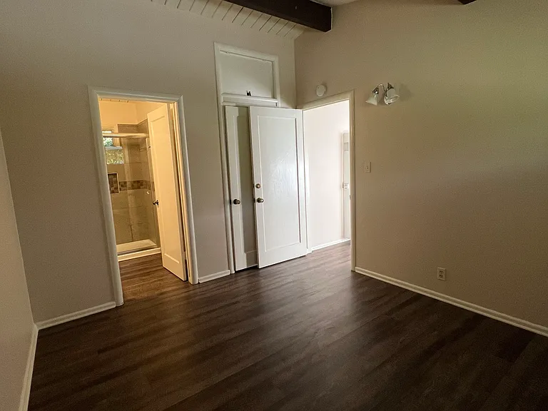 this is standing in the corner of the bedroom looking into the ATTACHED bathroom. The door to the right leads back into the livingroom. Also see the closet door behind the open bedroom door and some storage up above the closet.