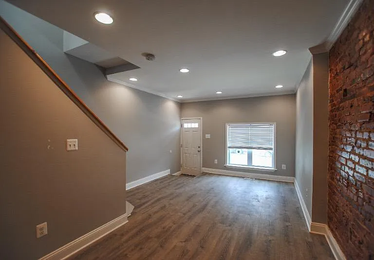 Walk in to an open first level with exposed brick in the living space