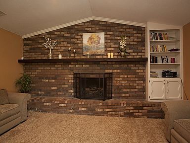 Brick fireplace and vaulted ceiling in living room