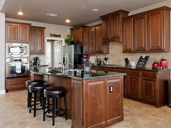 This kitchen is gorgeous with sleek granite, 42" cabinets, stainless steel appliances, and an oversi