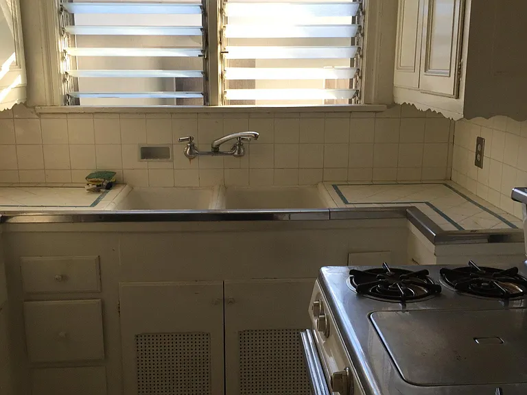 Deco tiled kitchen with stove (original griddle on top) and new stainless steel refrigerator.