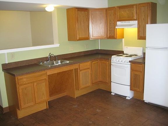 L-shaped kitchen with oak cabinets. Stove and refrigerator included.