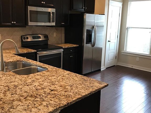 Kitchen with granite countertops, tile backsplash and stainl