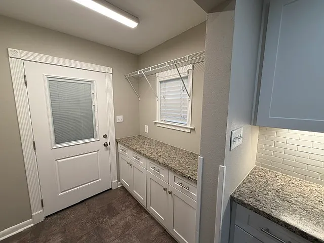 Exterior back door leads to covered patio inside fully fenced in yard.