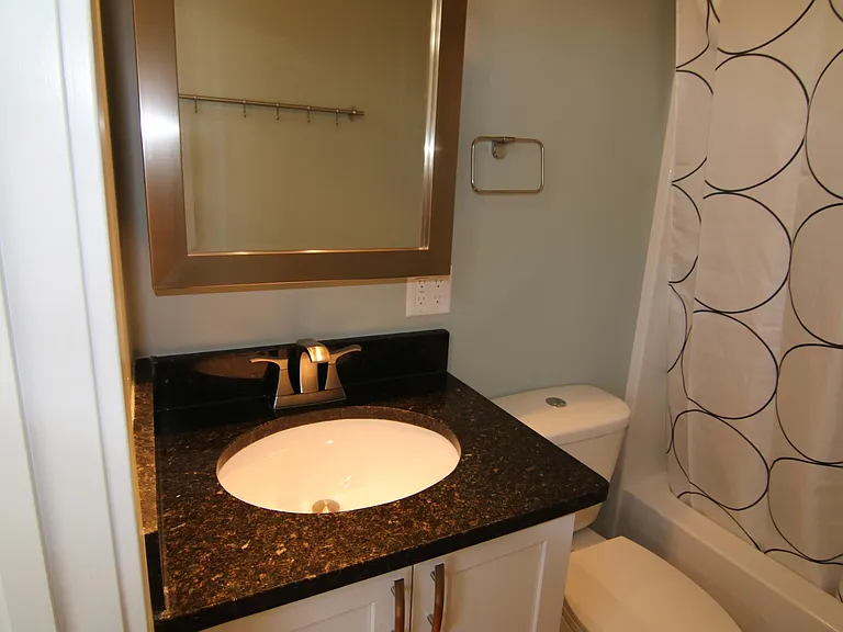 Bathroom with full size tub shower combo.