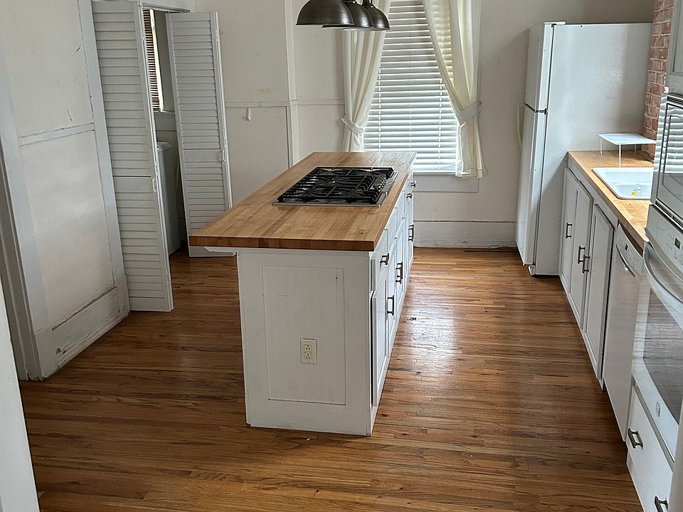 Kitchen looking in from dining room. The island has Bosh 5 burner cook top. The oven and microwave are built in on the right with dishwasher.