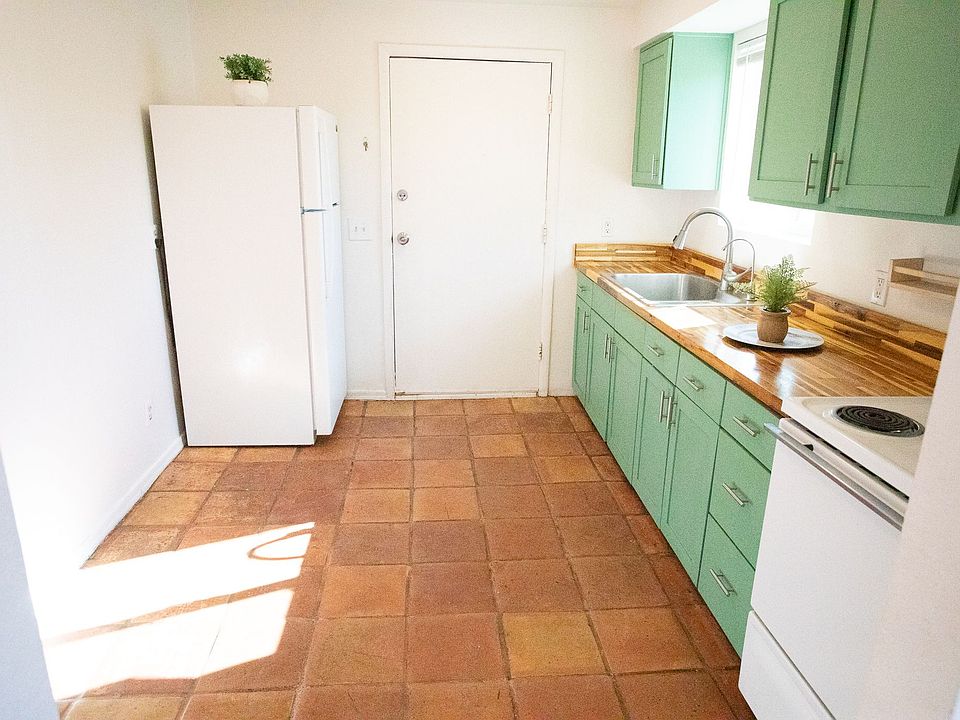 The kitchen features bright cabinetry and a warm butcher block countertop that creates an inviting workspace. The reverse osmosis system delivers clean, refreshing water straight from the tap, while the spacious layout offers room for a proper dining tabl