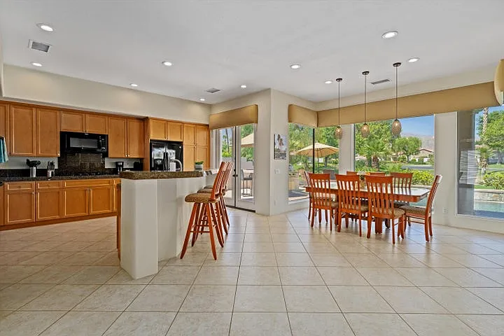 Kitchen and dining area w/ center island, ceramic tile floors and oversized windows.