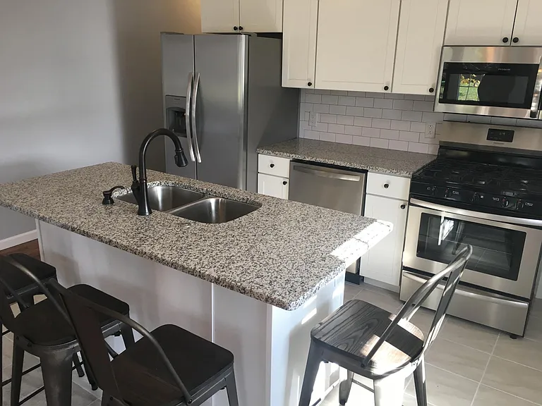 All new kitchen with island, four bar stools provided, new stainless steel appliances (dishwasher, gas stove, fridge with water/ice maker, microwave), granite counter tops, subway backsplash tile, garbage disposal, new tile floor.