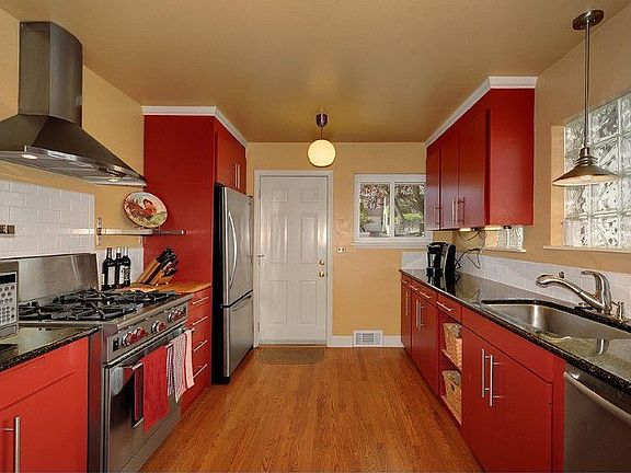 The remodeled chef's kitchen features a Wolf range, hardwood floors, subway tile back splash, stainless appliances and an exterior door to the courtyard.