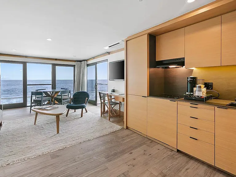 A kitchenette with mini-fridge and freezer, Broan cooktop fully stocked with drinkware, flatware, and dinnerware. A Nespresso Vertuo, coffee station with pods, Breville toaster oven, iron tea kettle and Ninja blender for preparing smoothies andlight meals