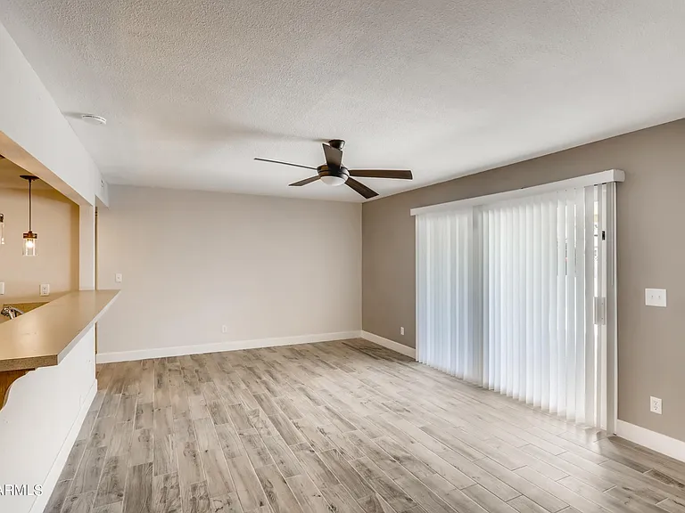 Large den / common area room with eat in bar & sliding glass door to patio.