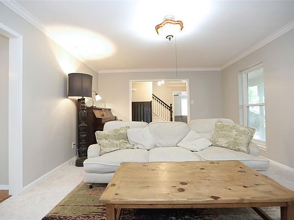 The formal living with new carpet, neutral pain, and elegant crown molding.