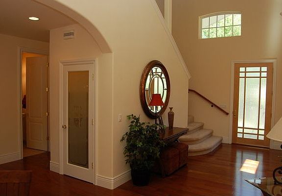 Gorgeous wood and glass door invites you into the dramatic entry way.