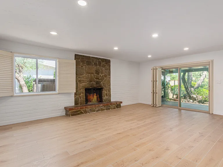 GREAT ROOM WITH FIRE PLACE AND SLIDING GLASS DOOR LEADING TO PATIO AND YARD