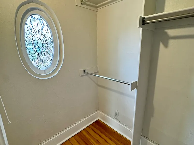 Second photo of primary bedroom closet with original lead glass window