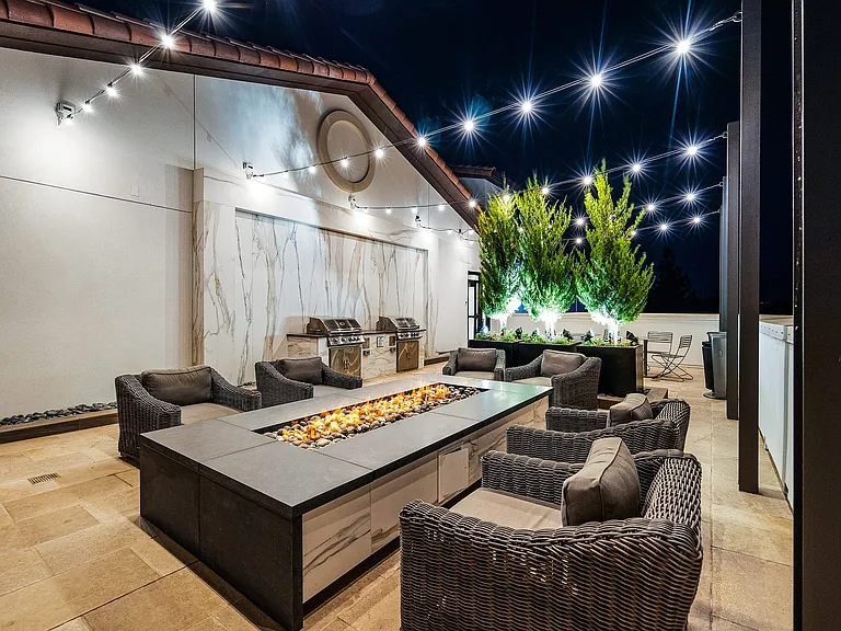 Rooftop terrace with fire pit, string lights, and plush seating