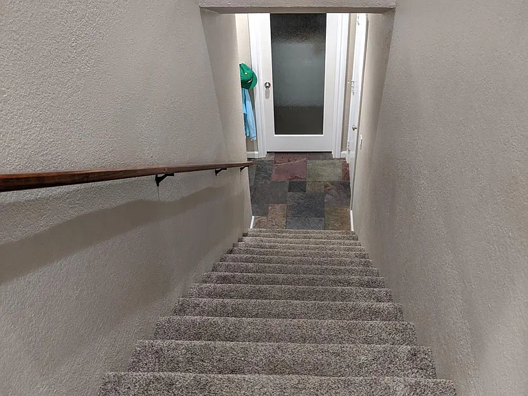 View downstairs.Behind the glass door is the laundry room. The door on the right is to the two car garage. On the left is the front door.
