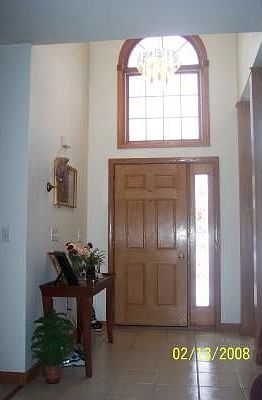 Foyer: Open ceramic foyer with palladian window and glimmering chandelier.