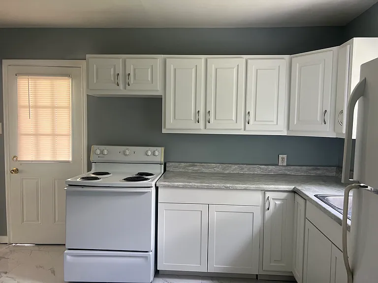 Remodeled kitchen with new cabinets and porcelain tile floor