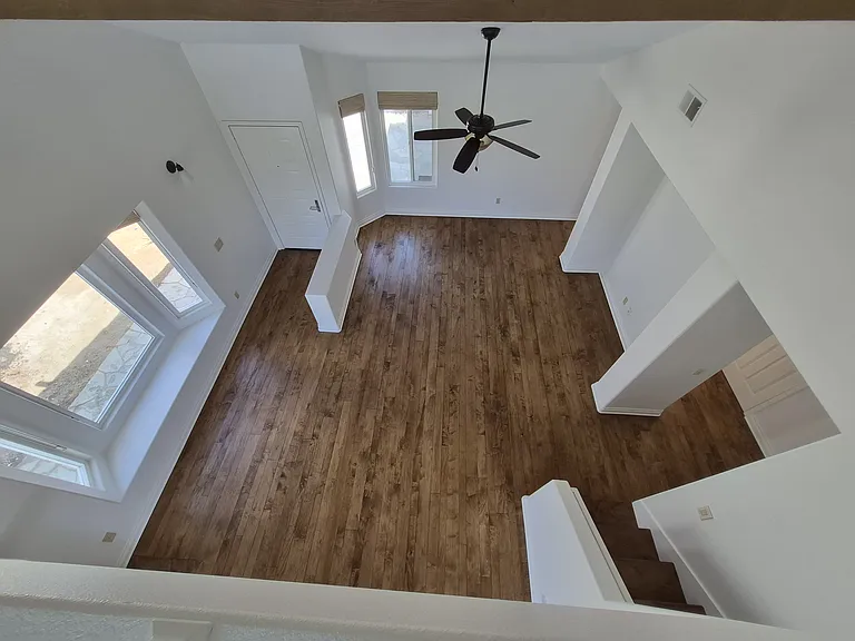 Birds-eye view of main living area from loft. High ceilings and beautiful wood beams accent this airy and bright living space.