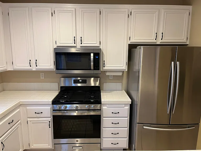 Stainless steel upgraded appliances including fridge, dishwasher, gas stove and microwave range, plenty of kitchen storage
