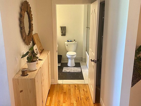 Hallway to bathroom with extra shelving for storage. 

Washer and dryer located behind bathroom door in the right side of the hallway.