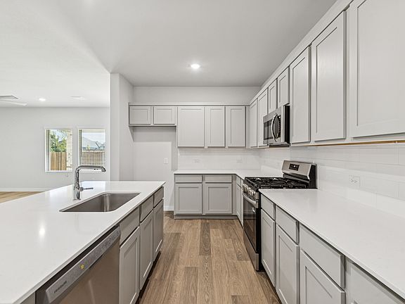 Kitchen in the Oscar home plan by Trophy Signature Homes - REPRESENTATIVE PHOTO