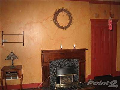Large great room with fireplace (inoperable) and ceiling fan