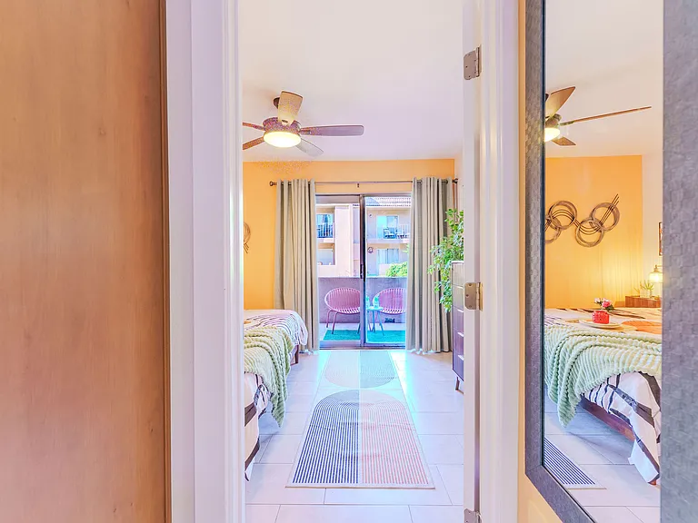Walkout from primary to spacious deck facing green, community grill and seating area