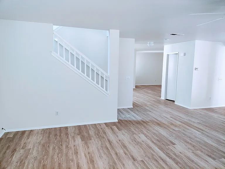 View from family room showing stairwell, bathroom door, and dining room