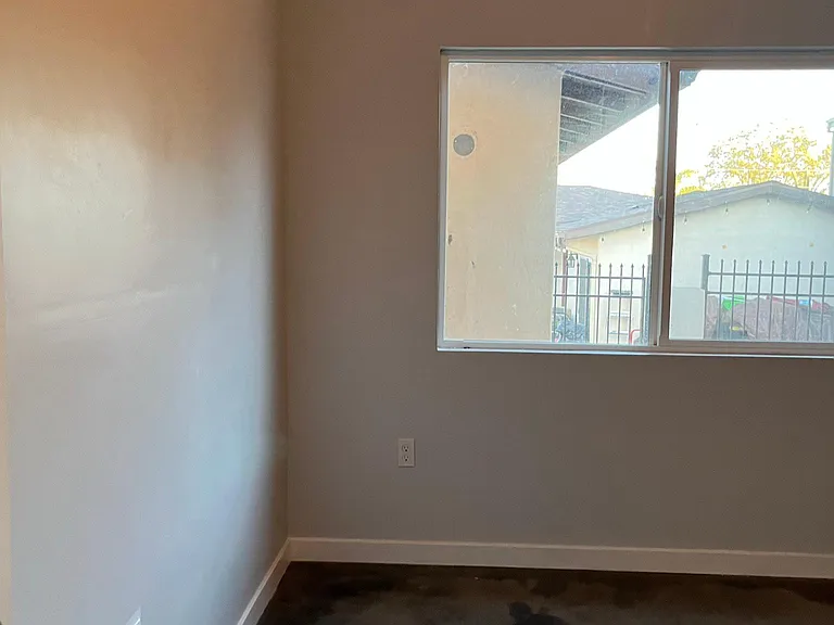 second bedroom, large windows, concrete stained flooring