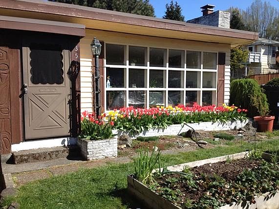 Exterior paint recently updated to blue. Garden beds ready for summer plantings!