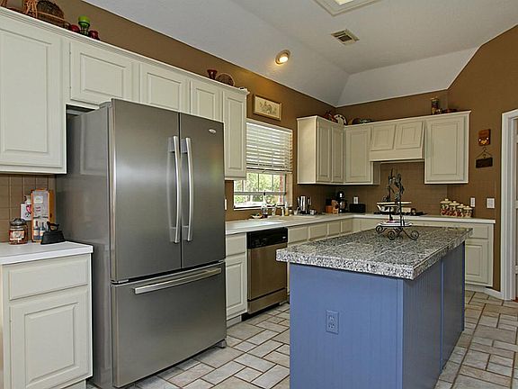 The large island kitchen has sculpted ceilings and amble storage and counter space.