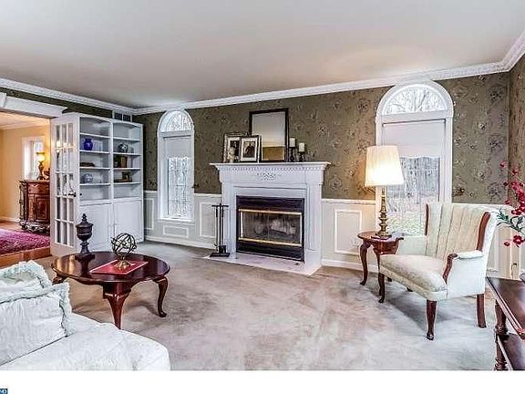Classic : Wood-burning fireplace, shelving and French doors leading to dining room